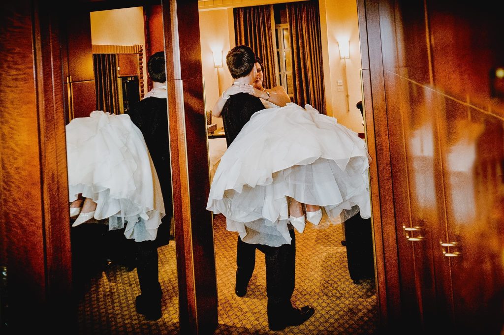 A groom carrying his bride over the threshold into their honey moon sweet captured as a fine art manifestation by Arnold Szmerling during an exclusive collaboration with the King David Jerusalem for the Visual Life Collection.